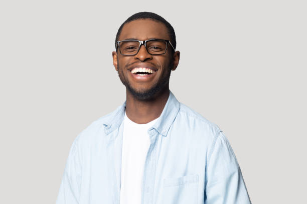 istockphoto-1207856385-612x612 Joyful happy african american young man in eyeglasses portrait. Isolated on grey studio background smiling millennial black guy looking at camera, laughing, having fun, posing for photo head shot.